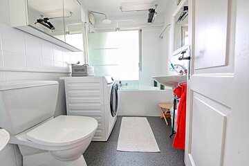 A bathroom with a toilet a sink and a washing machine