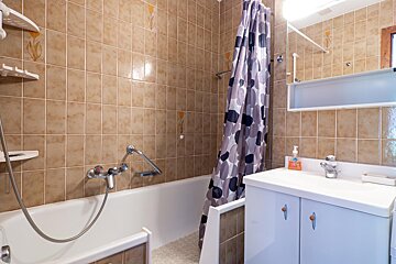 A bathroom with a bathtub a sink and a shower curtain
