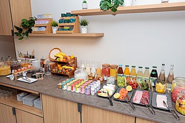 A buffet with a variety of food and drinks including a bottle of tropicana