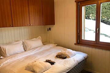 A bedroom with a bed and a window with snow outside