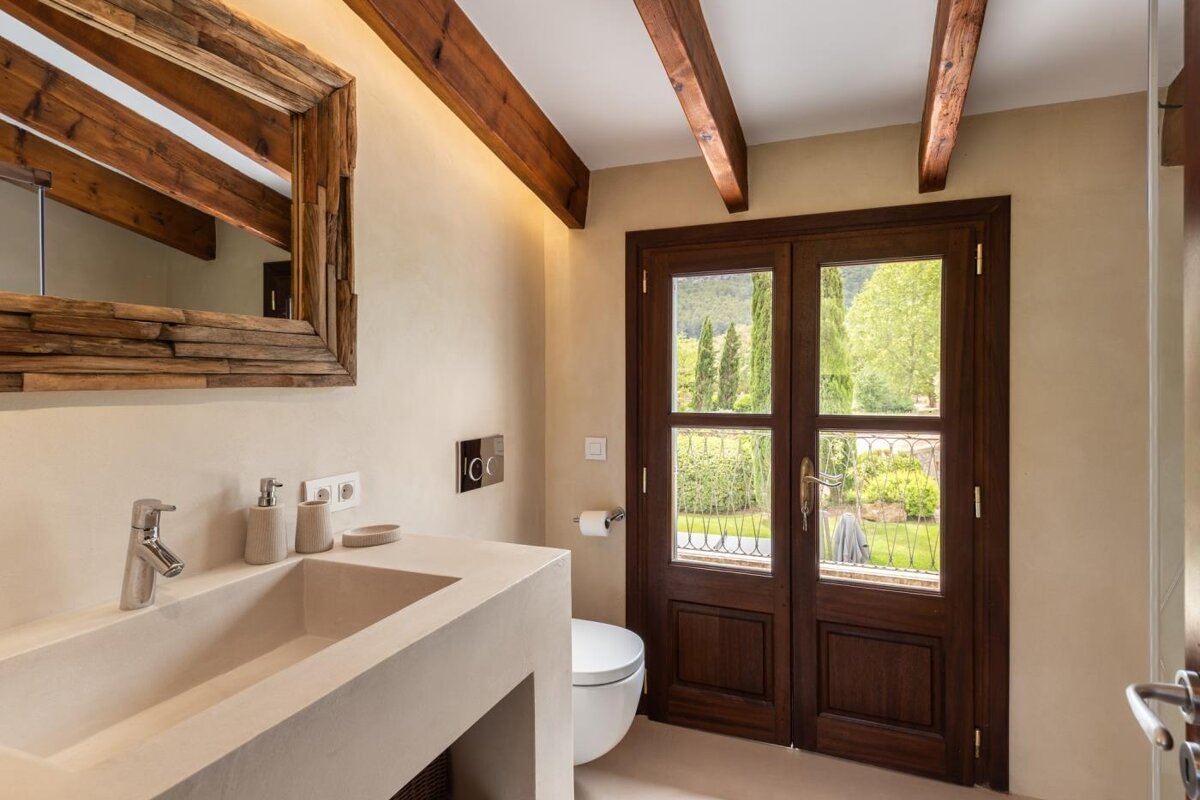 A bathroom with a toilet a sink and a mirror