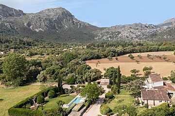An aerial view of a house with mountains in the background