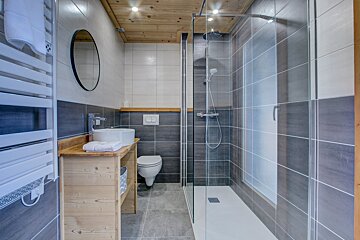 A bathroom with a toilet a sink and a shower