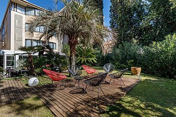 A patio with chairs and tables in front of a building