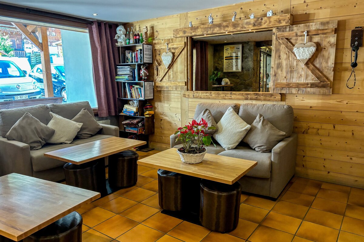 A living room with a couch and a table with a plant on it