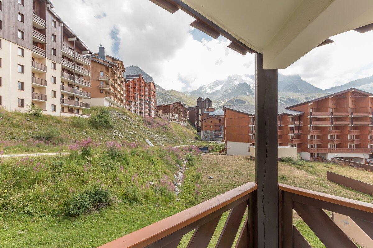 A balcony with a view of buildings and mountains