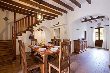 A dining room with a wooden table and chairs