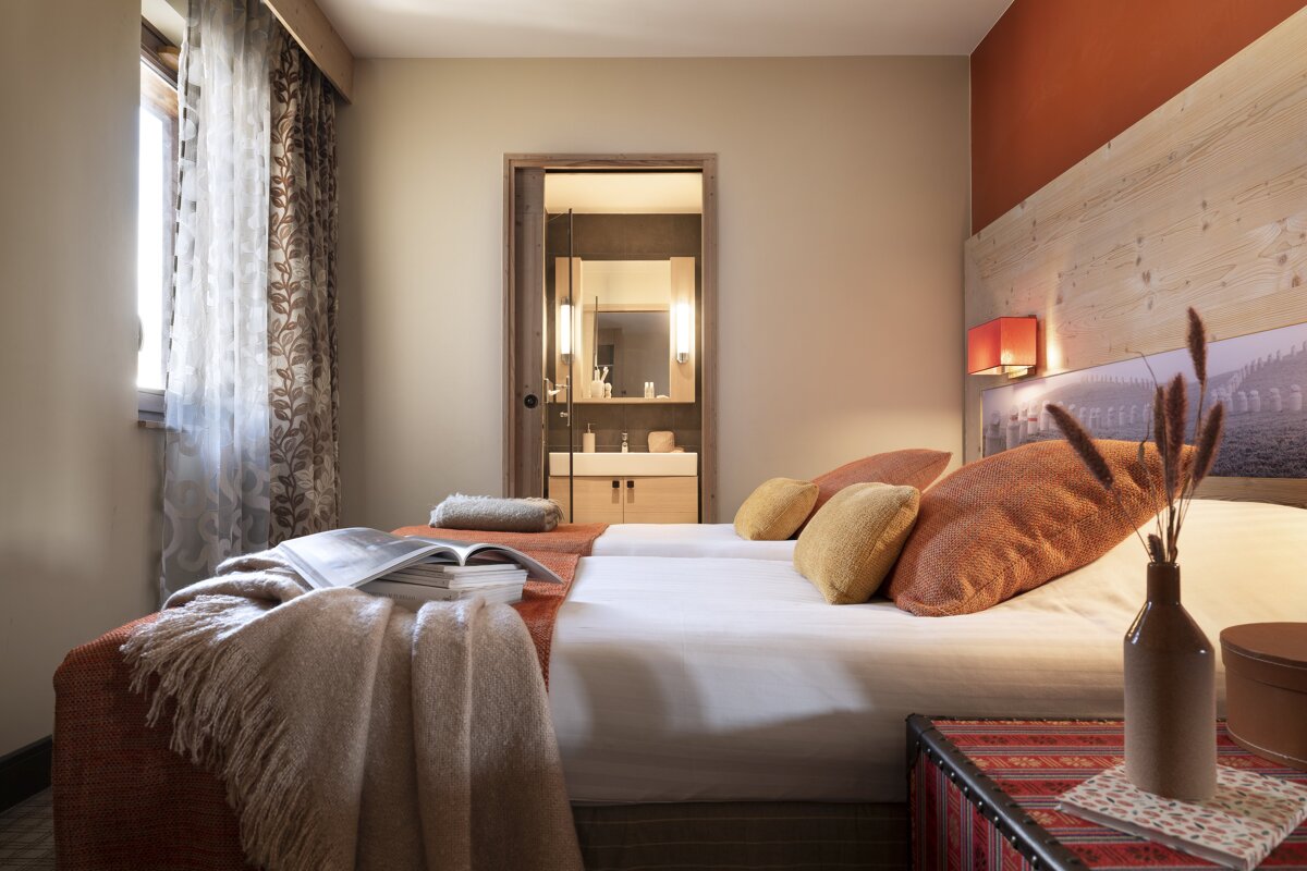 A bedroom with two beds and a book on the bed