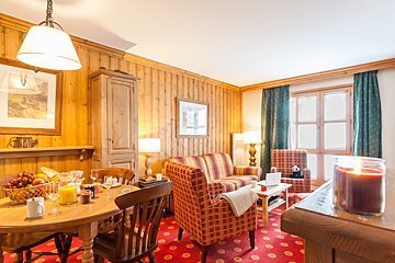 A living room with a couch and chairs and a candle on the table