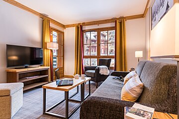 A living room with a couch a chair and a flat screen tv