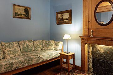 A corner of a room with a couch and a fireplace