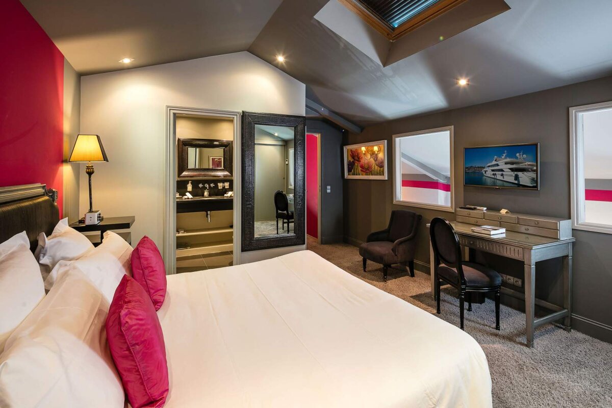 A hotel room with a large bed and a desk