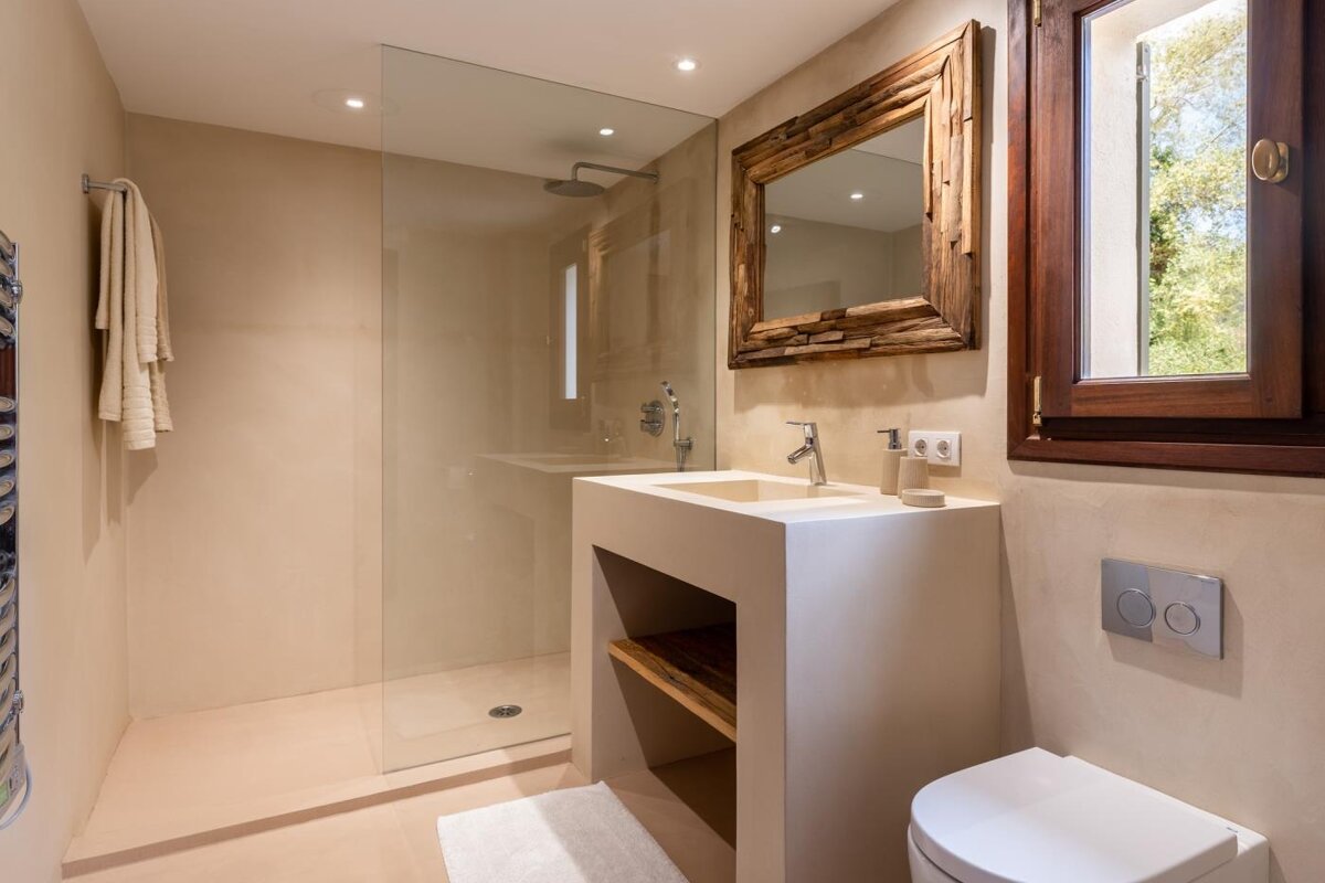 A bathroom with a toilet a sink and a mirror