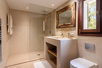 A bathroom with a toilet a sink and a mirror