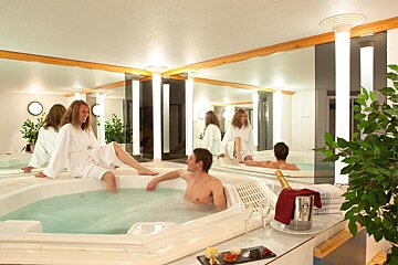 A man and a woman are sitting in a jacuzzi