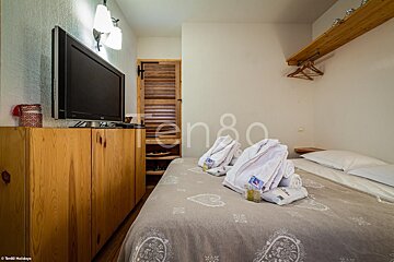 A bedroom with a bed and a flat screen tv taken by ten80 holidays