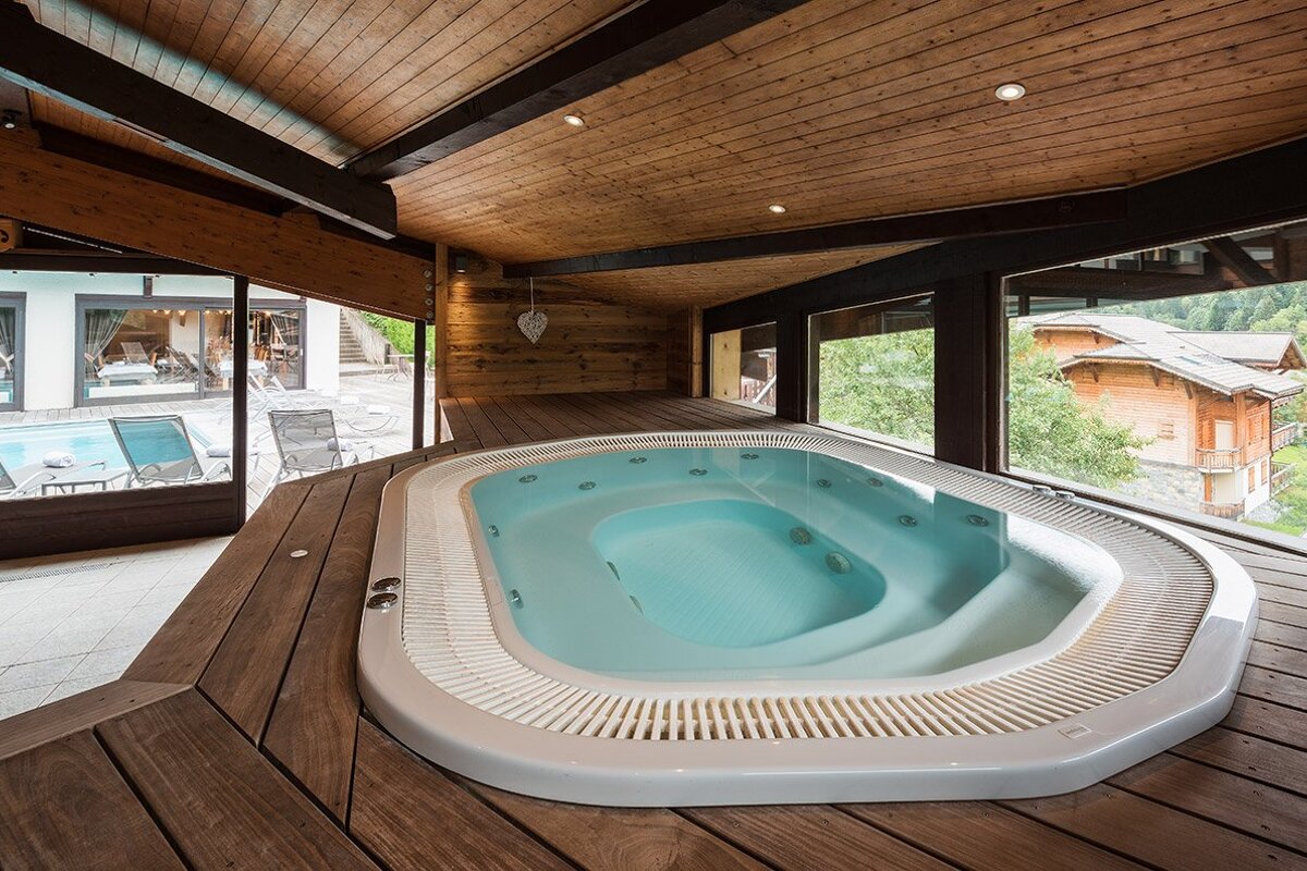 A large jacuzzi in a room with lots of windows
