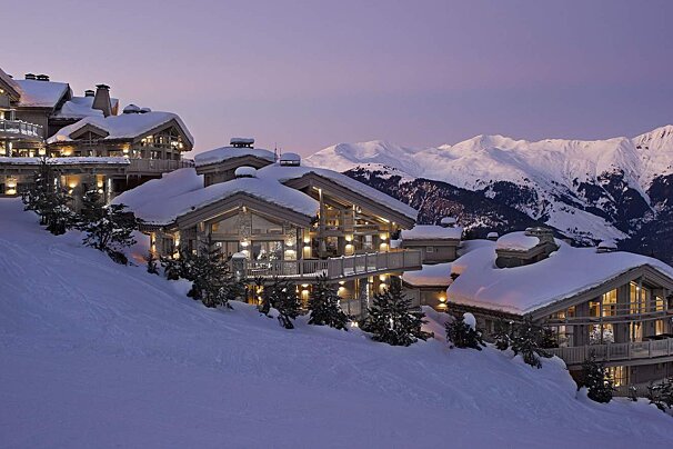 A snowy mountain with a large house in the foreground