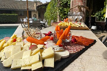 A variety of cheeses and vegetables on a table outside