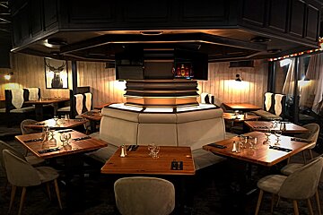 A dining room with tables and chairs and a deer picture on the wall