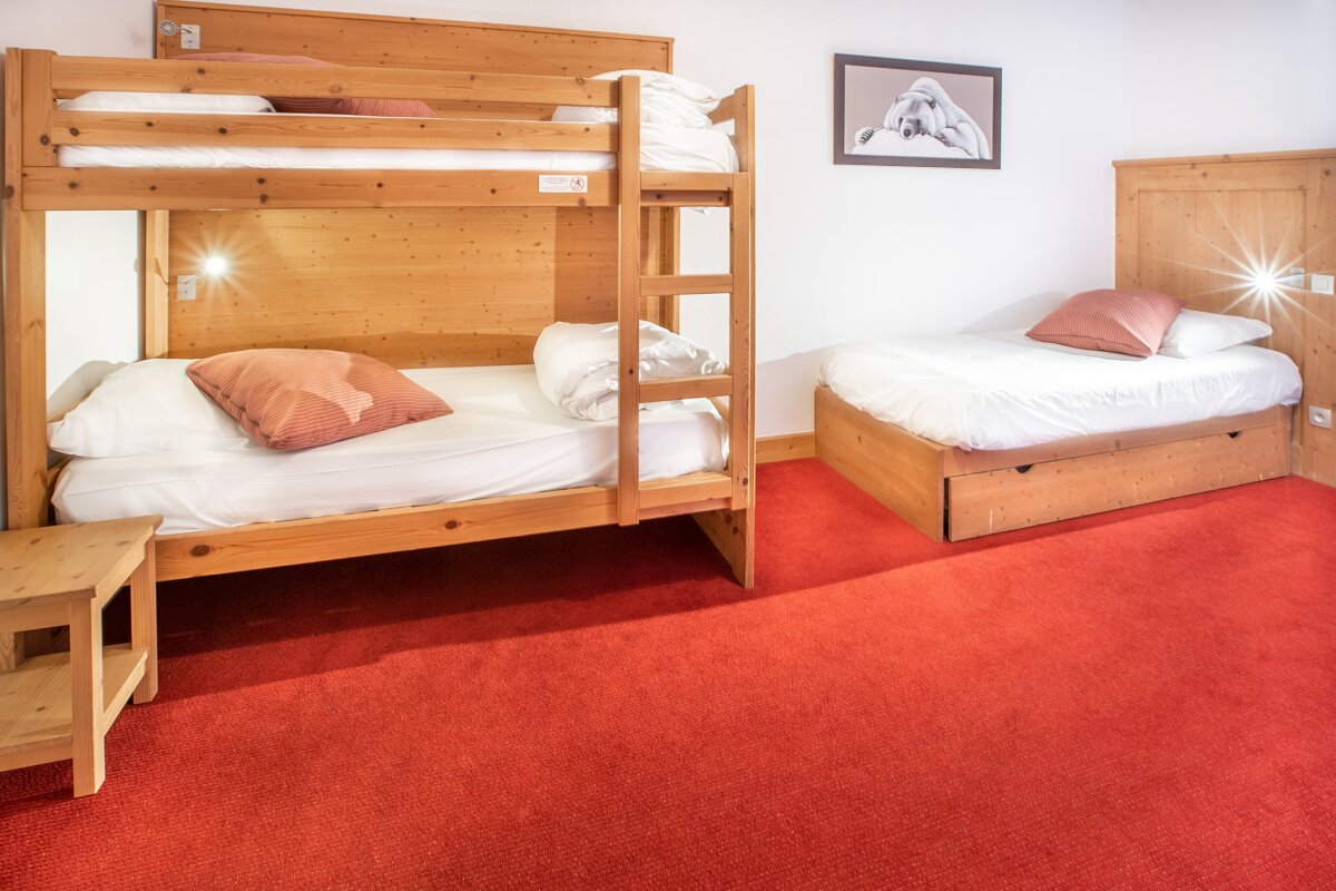Two bunk beds in a room with a red carpet