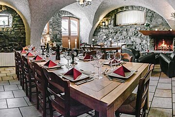 A long wooden table with a fireplace in the background