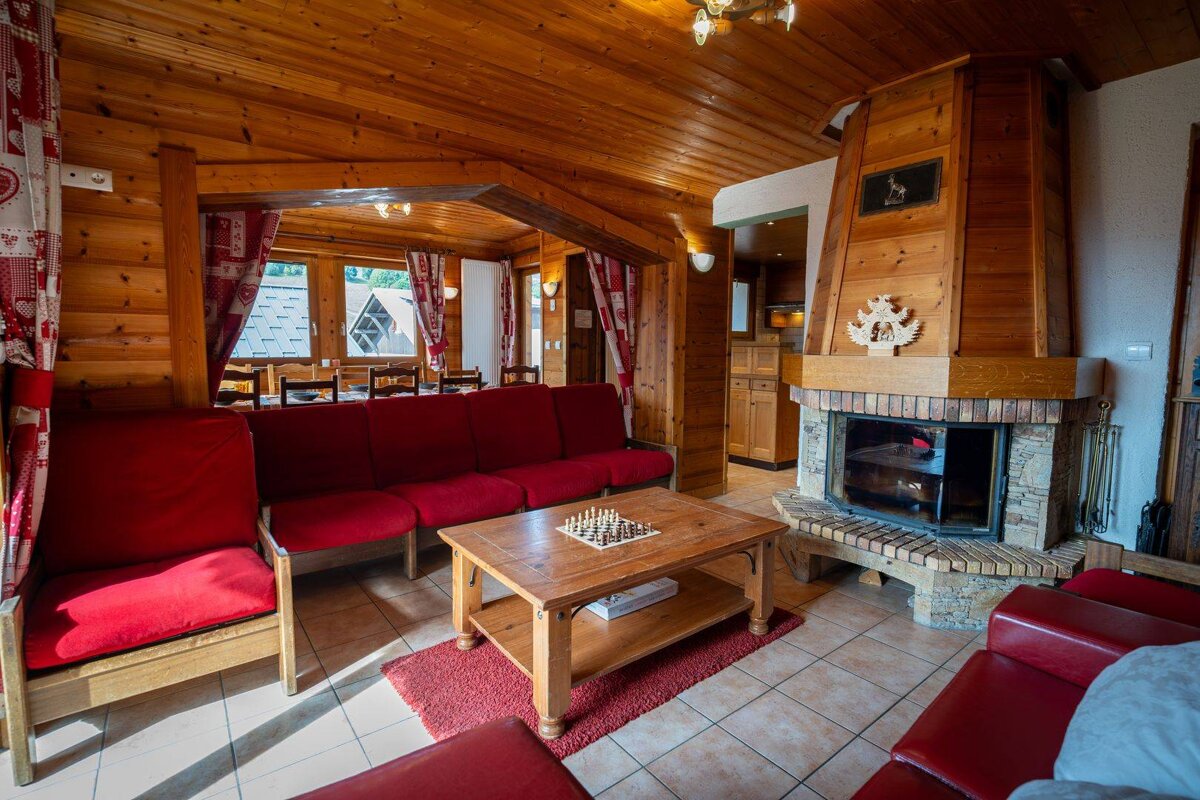 A living room with red furniture and a fireplace
