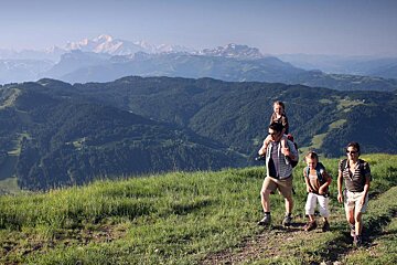 A family hiking in the mountains with mountains in the background