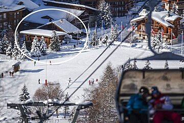 A ski lift is going down a snow covered slope