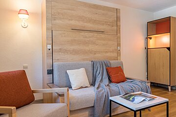 A living room with a couch and a table with a magazine on it