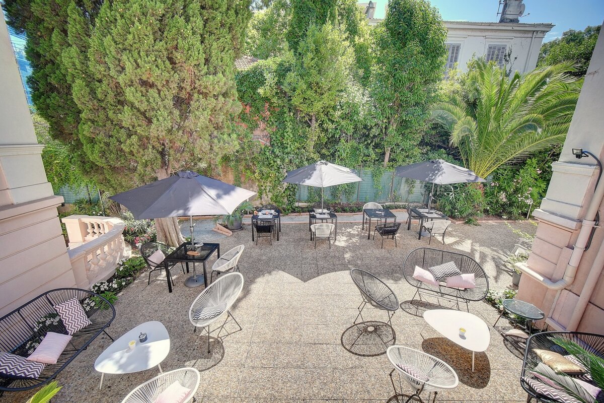 A patio area with tables and chairs and umbrellas