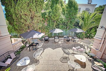 A patio area with tables and chairs and umbrellas