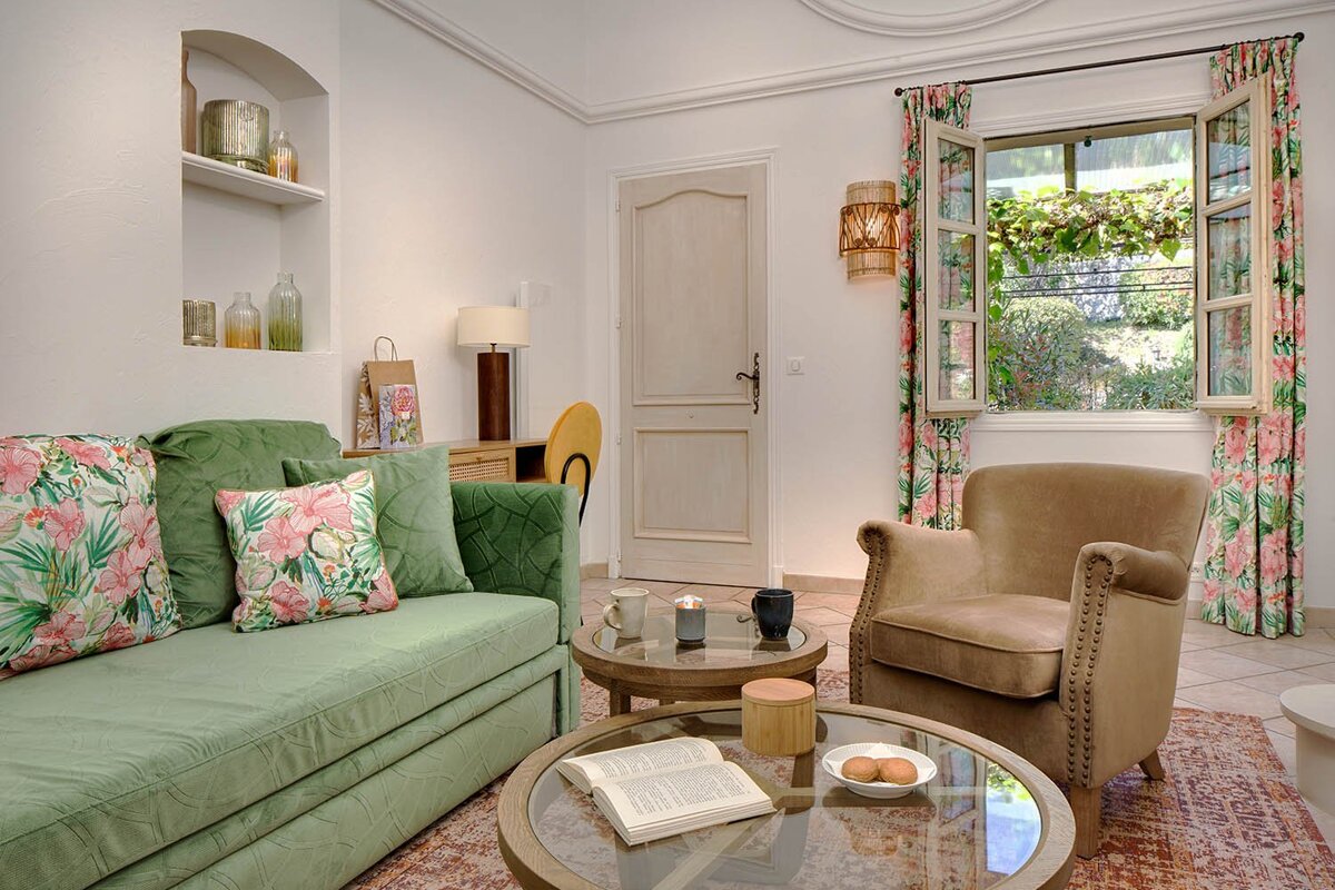 A living room with a green couch and a brown chair