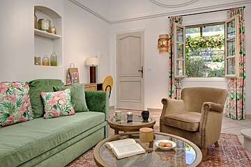 A living room with a green couch and a brown chair