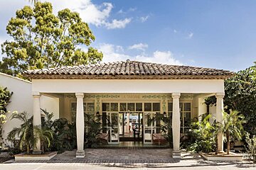 A white building with a tiled roof and a sign that says la tartine
