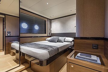 A bedroom with a bed and a window with blinds