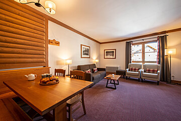 A living room with a table and chairs and a couch