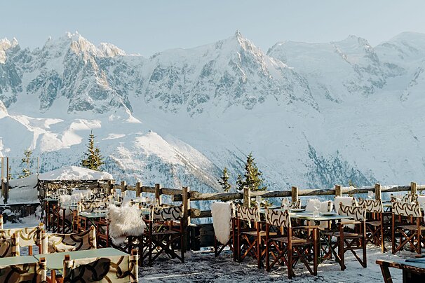 Tables and chairs in the snow with mountains in the background