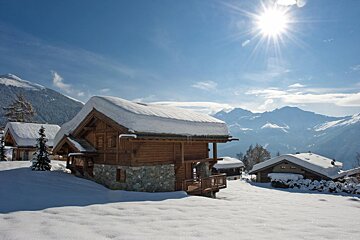 A snowy landscape with mountains in the background