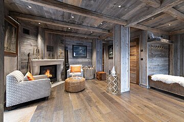 A living room with a fireplace and two chairs