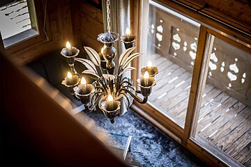 A chandelier is hanging from the ceiling in front of a window