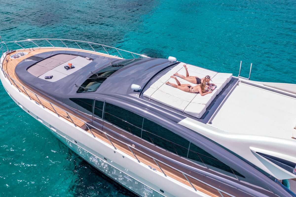 A couple laying on the roof of a boat in the ocean