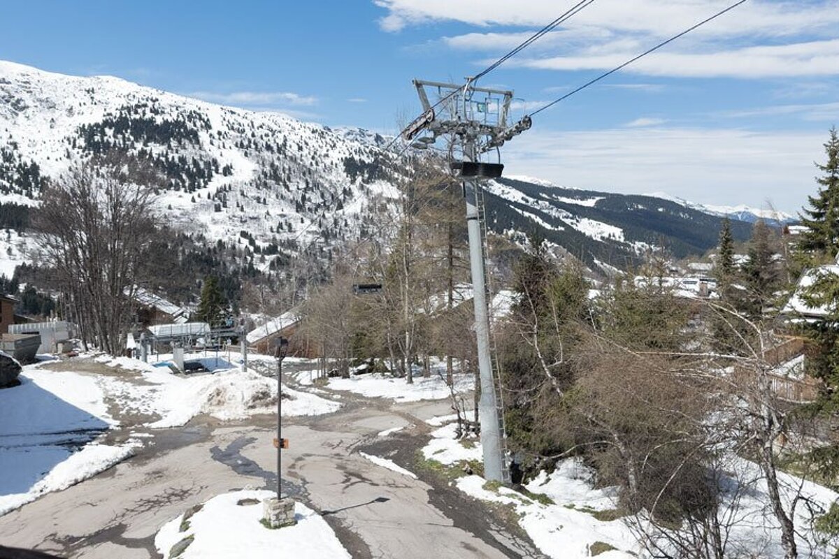 A ski lift is going up a snowy mountain