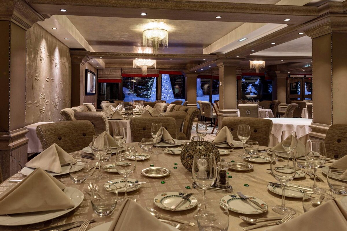 A dining room with tables and chairs set for a meal