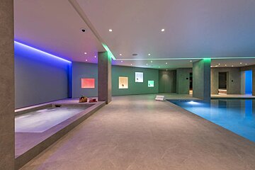 A large indoor swimming pool with a hot tub in the middle
