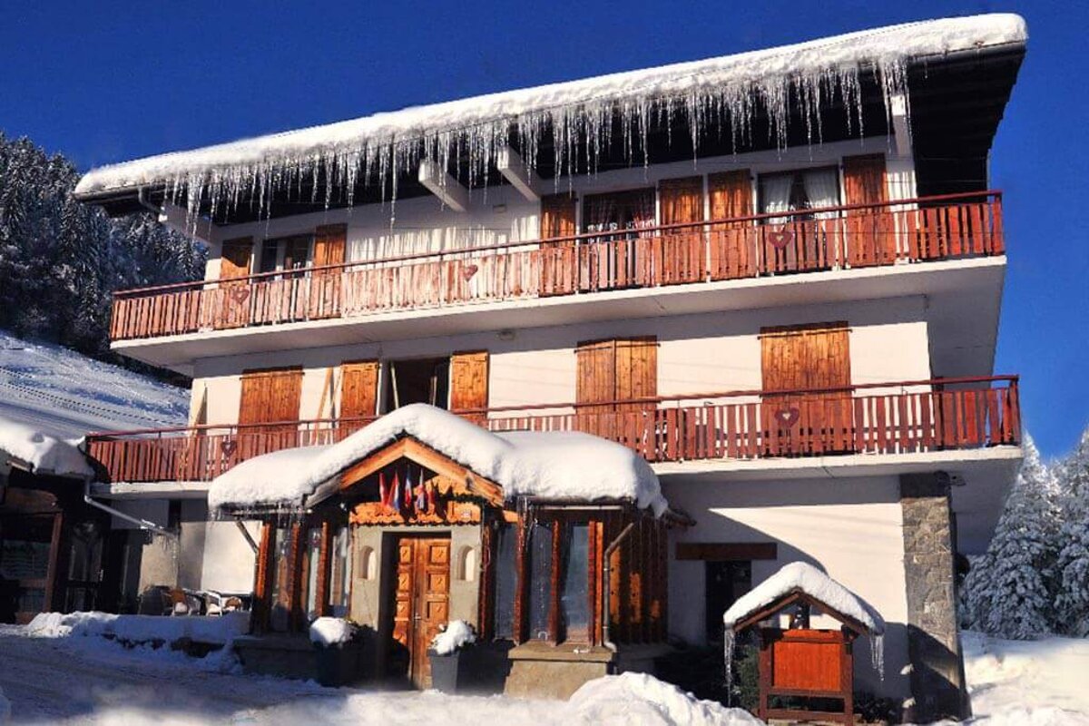 A snow covered building with icicles hanging from the roof