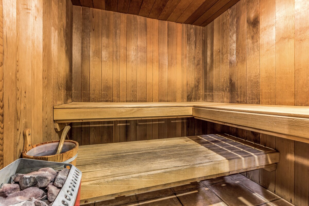 A wooden sauna with a bucket of rocks in it