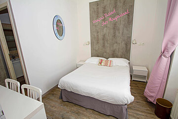 A bedroom with a bed and a wall that says françois tassart