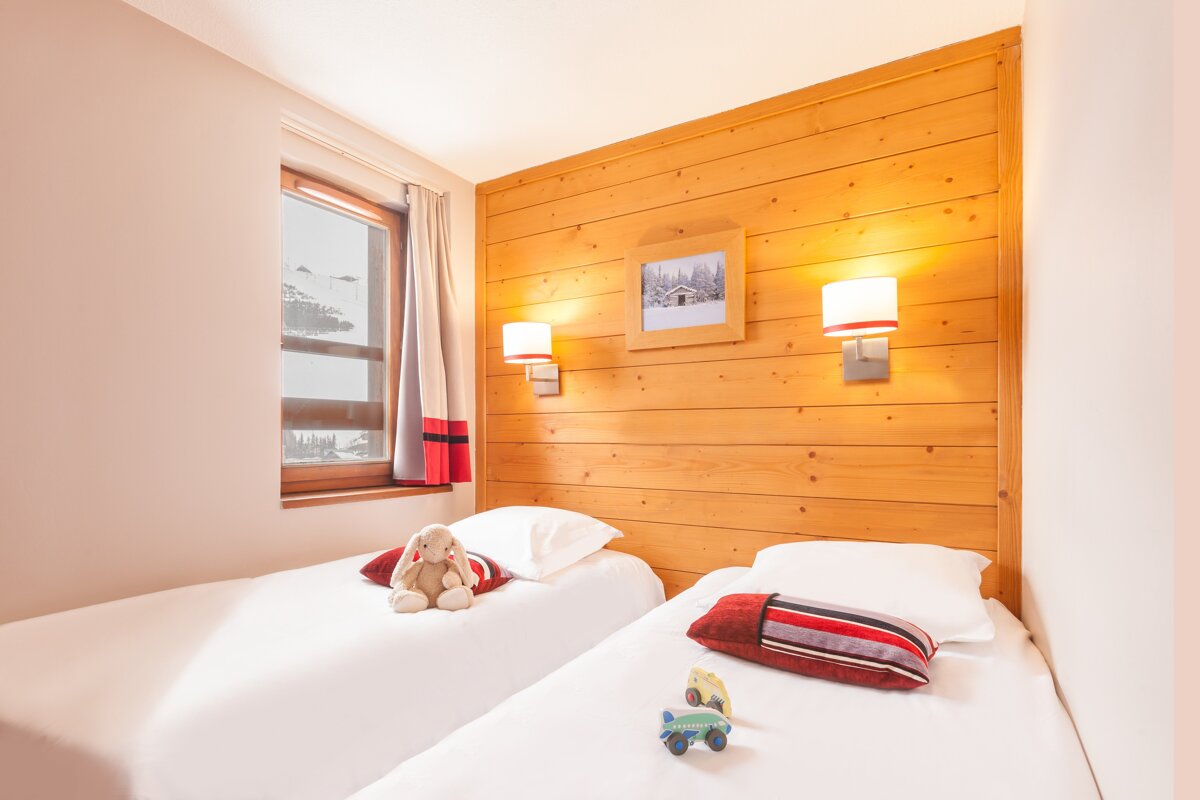 A bedroom with two beds and a picture on the wall