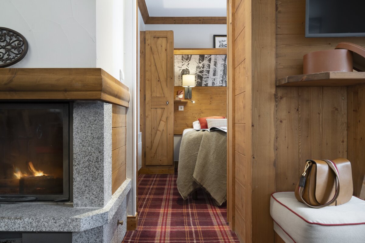 A bedroom with a fireplace and a bed